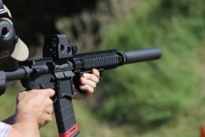 Man using bump stock on firearm while shooting