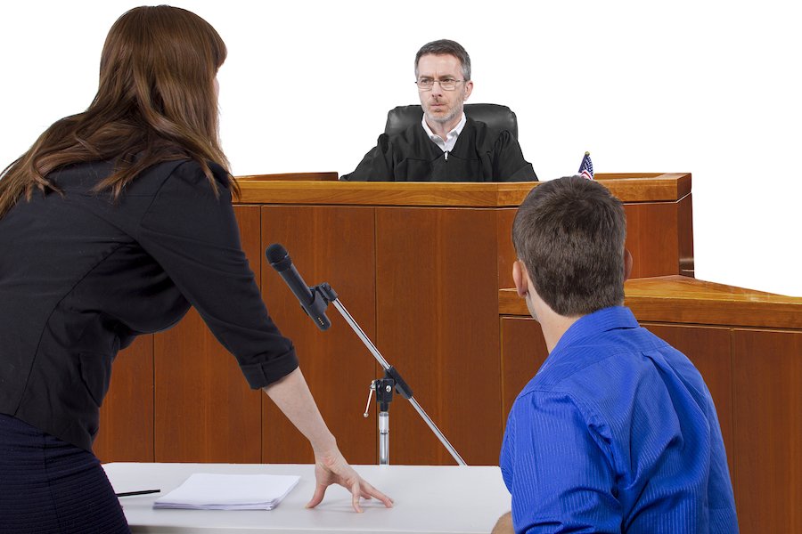 Abogado y acusado hablando con el juez durante la audiencia de fianza