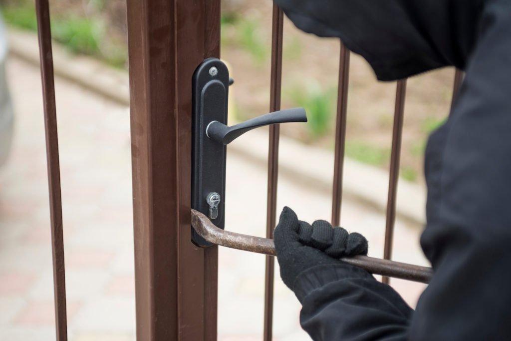 Primer plano de un hombre intentando entrar a una puerta exterior