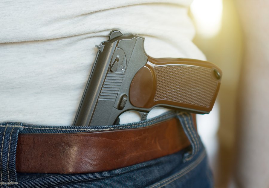 Man wearing gun behind his back.