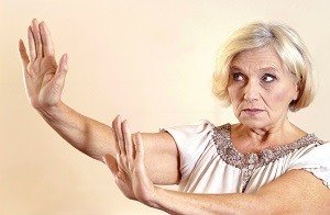 Una mujer anciana levantando sus manos