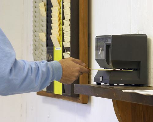 man punching out at time clock machine