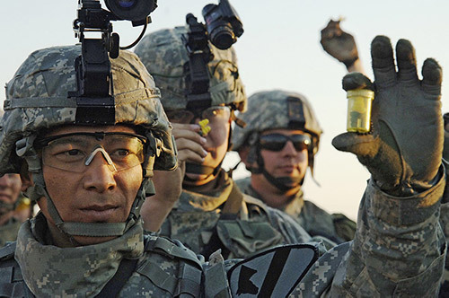 soldiers holding up their ear plugs