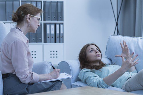 psychiatrist interviewing patient who is laying on couch