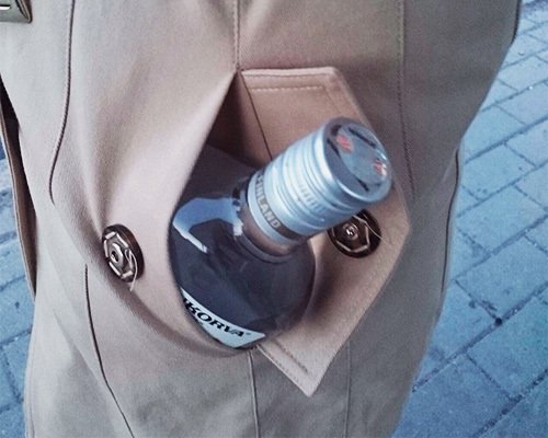 una botella de alcohol metida en el bolsillo de un abrigo - introducir alcohol en una cárcel o prisión de California es un delito según el Código de Negocios y Profesiones 25603 BPC
