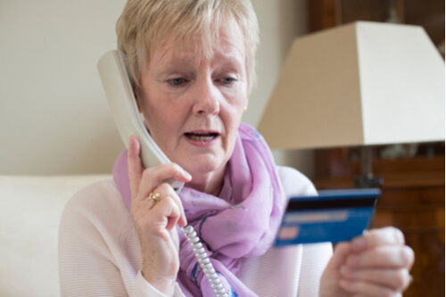 woman on telephone and holding her credit card