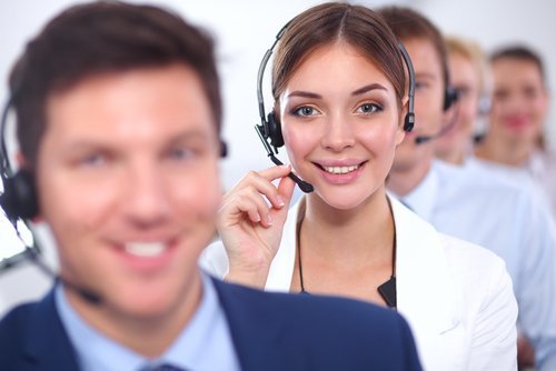 Row of five receptionists wearing headsets