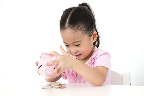 Una joven asiática sacando dinero de una hucha. Su padre no custodio paga la manutención infantil al padre custodio.