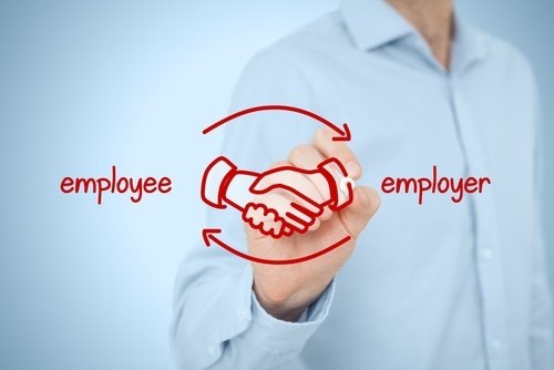 una persona dibujando con marcador en vidrio las palabras empleador y empleado
