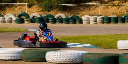 niño corriendo en un kart en una pista con neumáticos