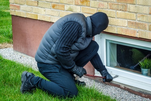 burglar breaking into a window of a house - Burglary is a crime in Nevada under NRS 205.060