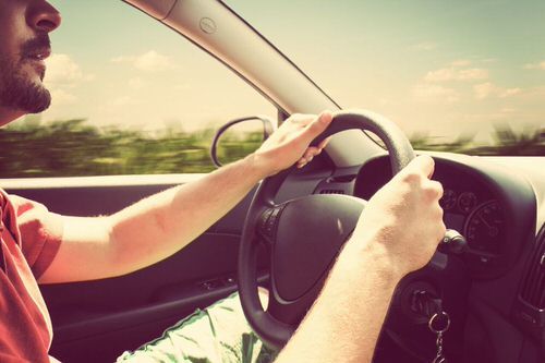 man behind the wheel of his automobile