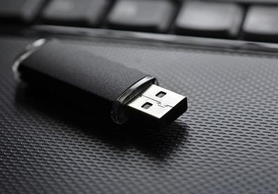 A USB flash drive placed on top of a laptop palm rest