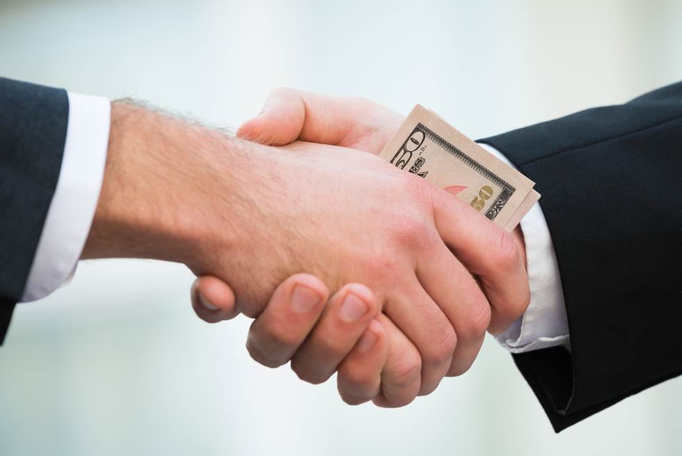 two men shaking hands with money in palms