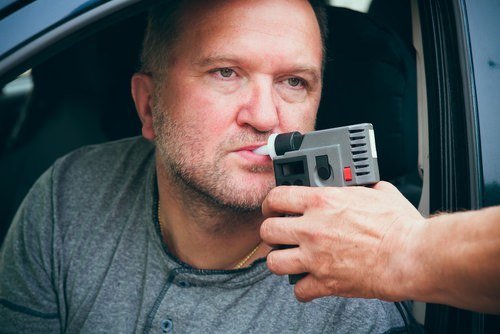 man being given breathalyzer test