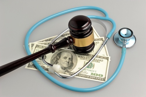 Judge's gavel and stethoscope over 3 $100 bills to illustrate health care fraud in Colorado. 