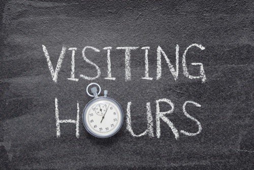 visiting hours written on a chalk board