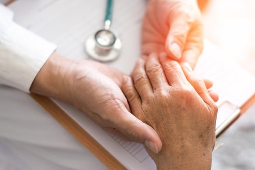 physician holding patient's hand