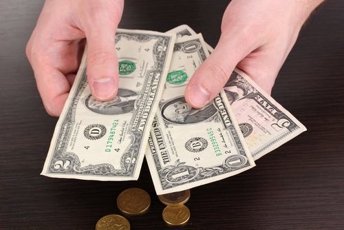 a person holding a few dollar bills