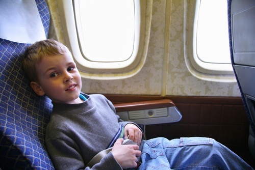 niño sentado en el asiento de la ventana del avión