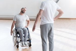 Hombre en silla de ruedas recibiendo terapia