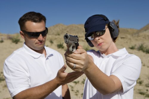 woman pointing a gun as part of firearms training