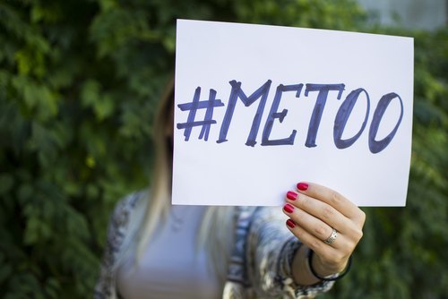 la mano de una mujer sosteniendo un letrero que dice "#MeToo"