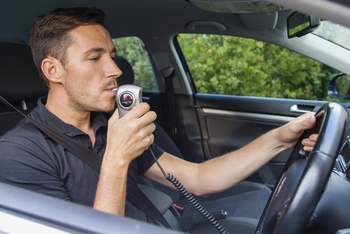 Hombre respirando en una máquina IID en el coche