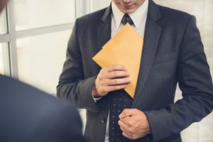 Man in business suit putting an envelope in his pocket