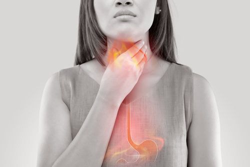 woman clenching her neck/throat in pain