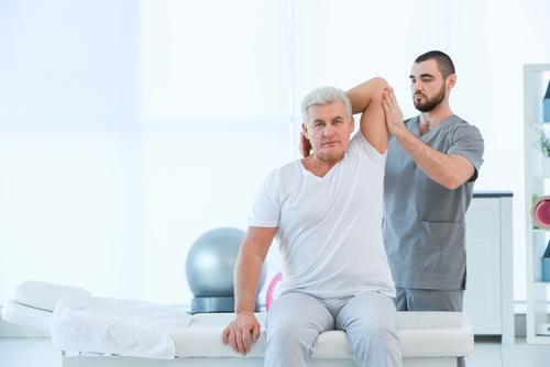 Physical therapist stretching a patient
