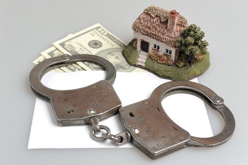 Handcuffs, money and a toy house to illustrate mortgage fraud in Colorado
