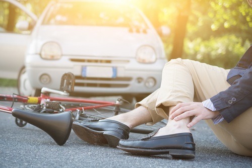 bicyclist lying on ground holding leg after being hit by car to illustrate negligence per se in Nevada