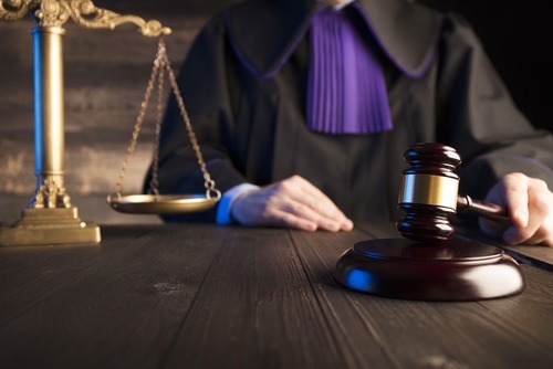 Judge in chambers banging gavel on desk after assigning a guardian.