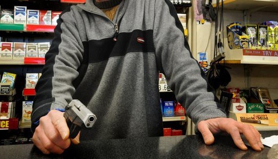 hombre con pistola en cajero a punto de cometer un robo