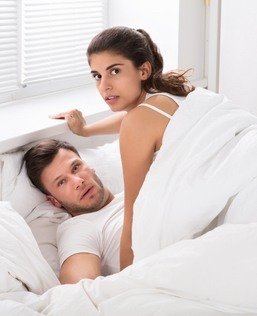 Pareja en la cama después de ser atrapada por el marido de la mujer a punto de violar el NRS 200.050.