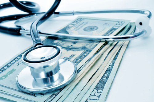stethoscope over stack of $20 bills - Medicare Set-Aside is money set aside from a workers' compensation settlement to pay future medical benefits