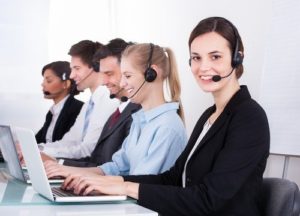 cinco recepcionistas de una firma de abogados con auriculares y computadoras portátiles
