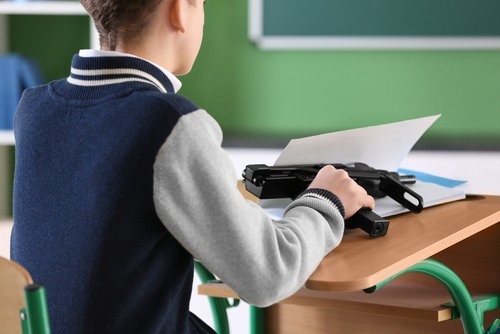 niño con arma automática en un aula como ejemplo de cuándo los padres en California pueden ser responsables por los daños causados por sus hijos