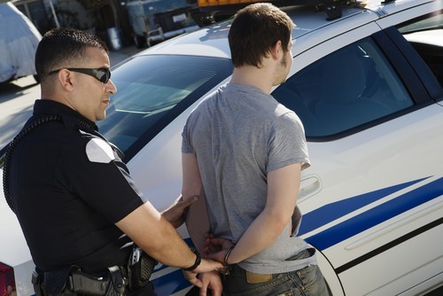 Police arresting and handcuffing man for failure to register as a sex offender under Penal Code 290 PC