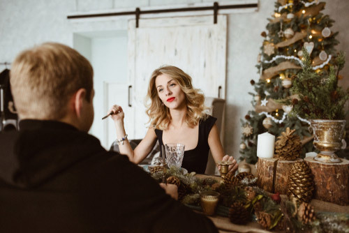 woman seated at table holding a knife