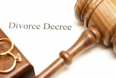 papel que dice decreto de divorcio, debajo de un anillo de bodas y un martillo de juez