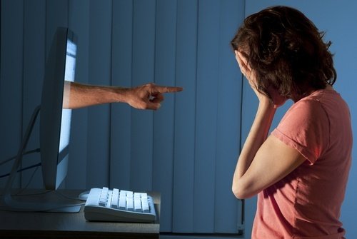 Finger-pointing projecting through computer at distressed woman