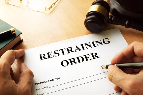 person filling out restraining order form