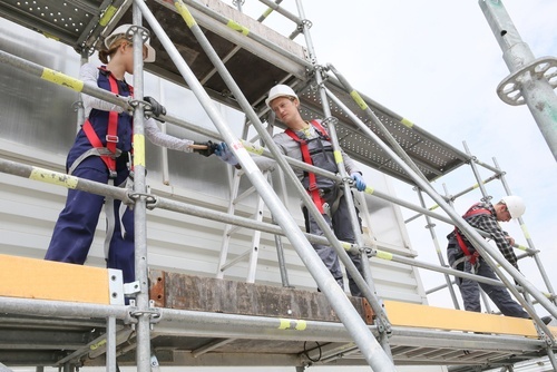 Three construction workers on a scaffold