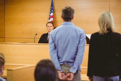 Handcuffed defendant in court before a judge