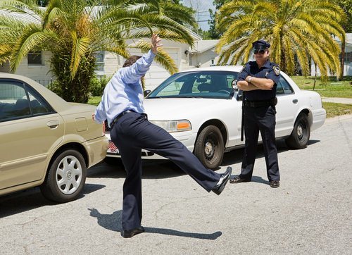 a suspect attempting the one leg stand test for a police officer