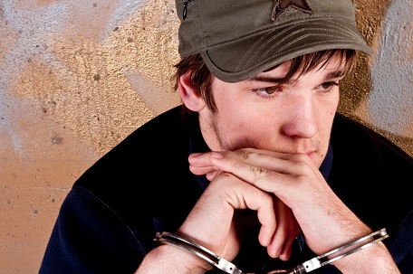 teenager with his hands cuffed