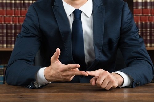 close-up of male lawyer ticking off reasons on his fingers