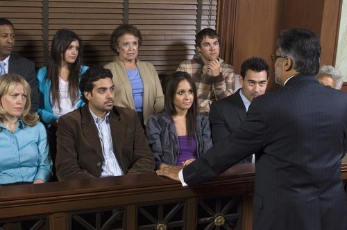 back of male lawyer as he talks to jurors in jury box
